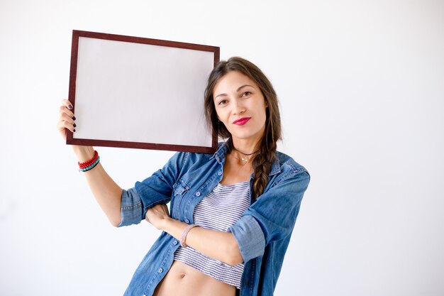 Mujer feliz con un cartel o cartel blanco en blanco