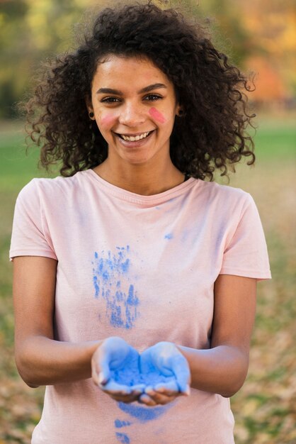 Mujer feliz celebrando holi con color