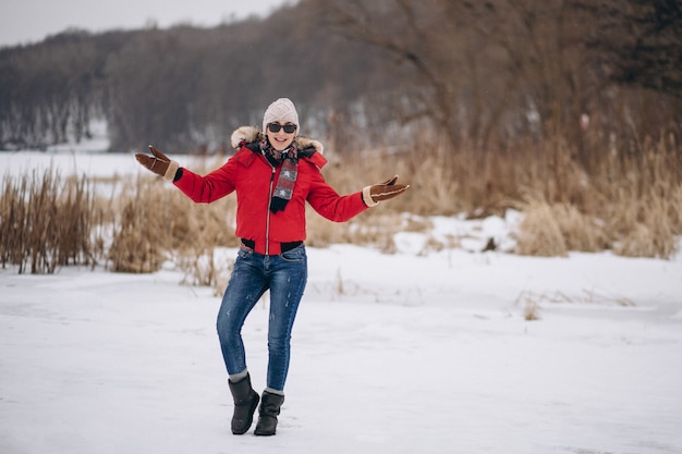 Mujer feliz en chaqueta roja afuera en invierno
