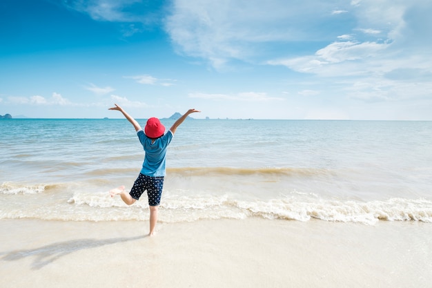 Mujer feliz en el cielo de la playa y de las nubes.