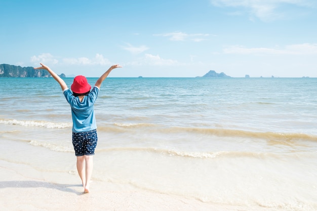 Mujer feliz en el cielo de la playa y de las nubes.