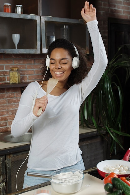 Foto gratuita mujer feliz en cocina cantando