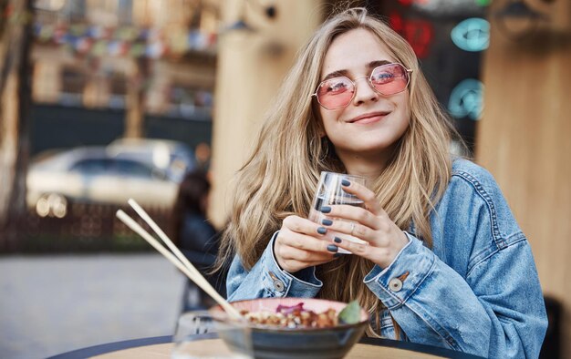 Mujer feliz comiendo comida asiática china al aire libre sentado en la calle