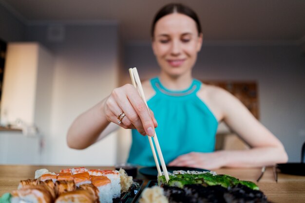 Mujer feliz comiendo delicioso sushi