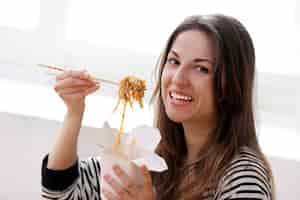 Foto gratuita mujer feliz comiendo fideos