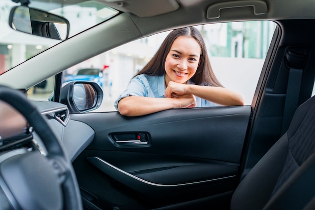 Foto gratuita mujer feliz en concesionario de coches