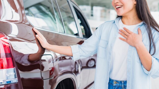 Foto gratuita mujer feliz en concesionario de coches