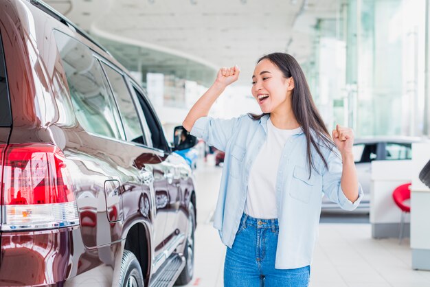 Mujer feliz en concesionario de coches