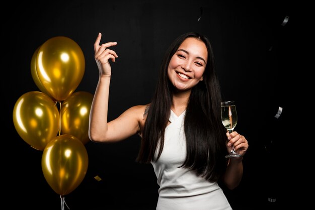 Mujer feliz con copa de champán en la fiesta de año nuevo