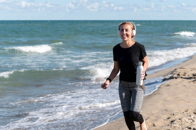 Mujer feliz corriendo en la orilla