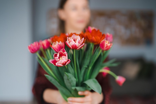 Mujer feliz disfruta de un ramo de tulipanes Ama de casa disfrutando de un ramo de flores y el interior de la cocina Dulce hogar Libre de alergias