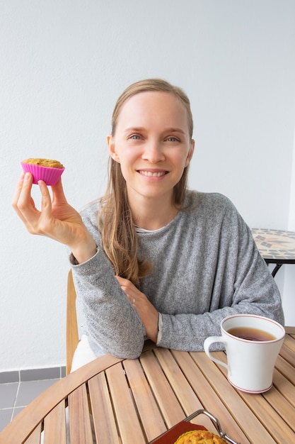 Mujer feliz disfrutando de un descanso para tomar café en casa