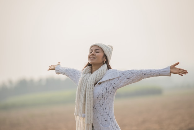 Mujer feliz disfrutando de la naturaleza idílica, celebrando la libertad y levantando los brazos.