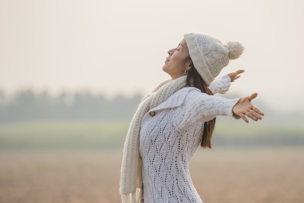 Mujer feliz disfrutando de la naturaleza idílica, celebrando la libertad y levantando los brazos.