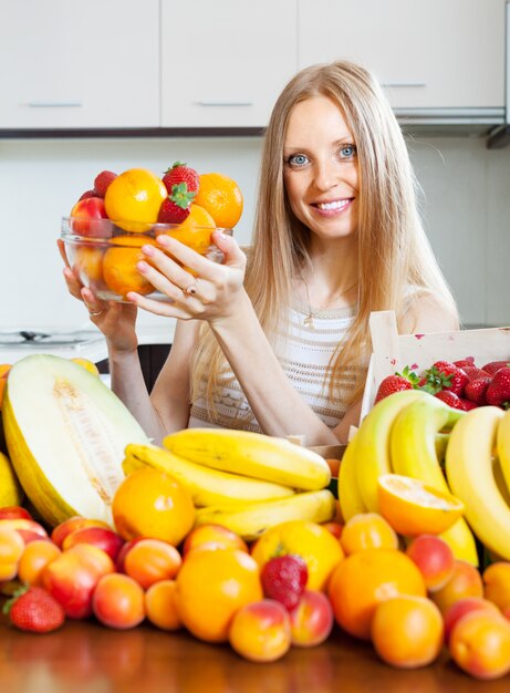 Mujer feliz con diversas frutas