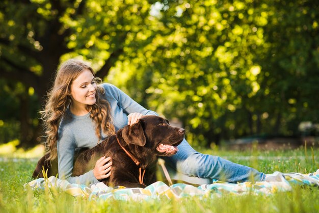 Mujer feliz divirtiéndose con su perro en el jardín