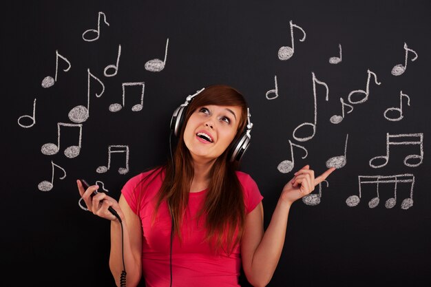 Mujer feliz escuchando música a través de auriculares