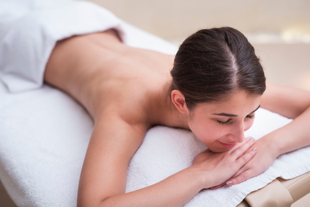 Mujer feliz esperando masaje en el spa