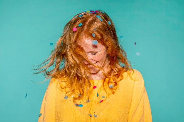 Mujer feliz de fiesta con confeti en el pelo