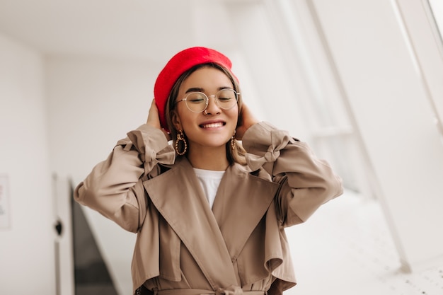 Mujer feliz con gafas sonriendo contra la ventana