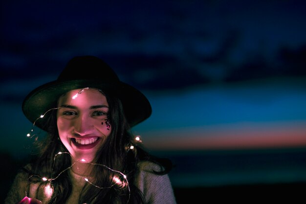 Mujer feliz con la guirnalda ardiente en la cabeza