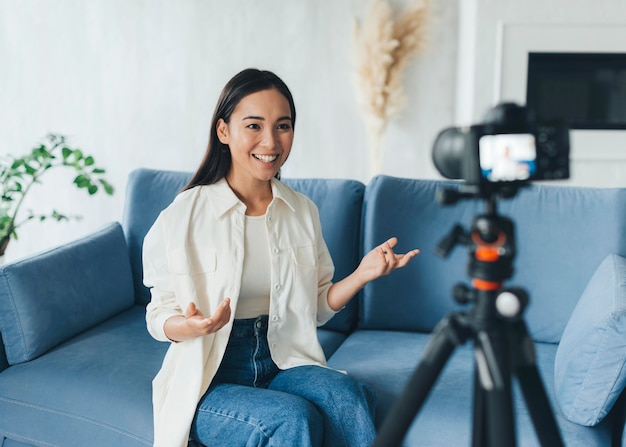 Mujer feliz haciendo un vlog en casa