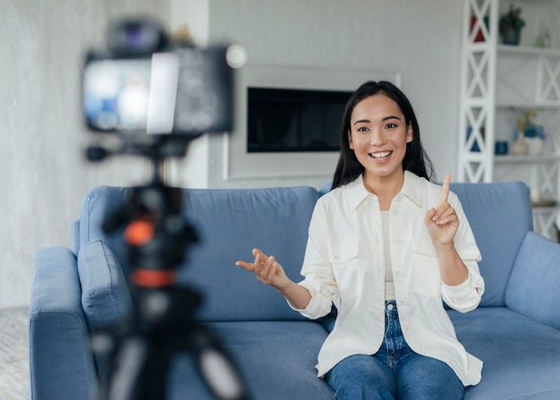 Mujer feliz haciendo un vlog en el interior