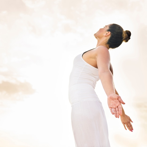 Foto gratuita mujer feliz haciendo yoga bajo el sol