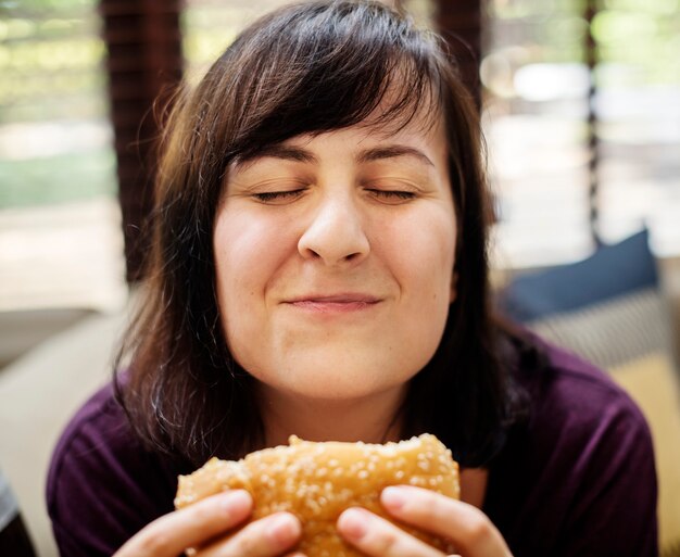 Mujer feliz con una hamburguesa grande