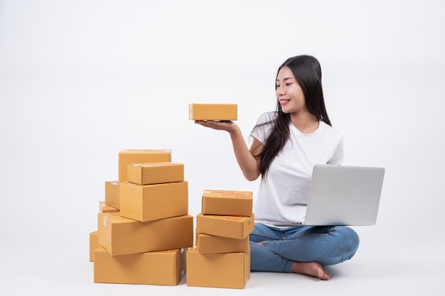 Mujer feliz Hay una caja de paquete en la mano. Fondo blanco Operadores de negocios de compras en línea