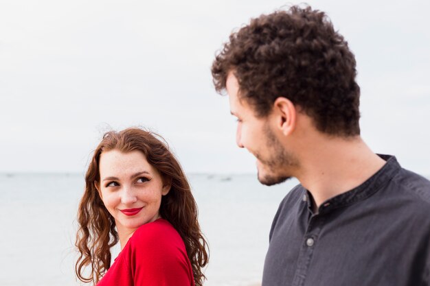 Mujer feliz con el hombre en la orilla del mar