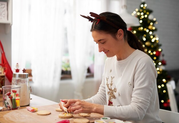 Mujer feliz horneando galletas para Navidad