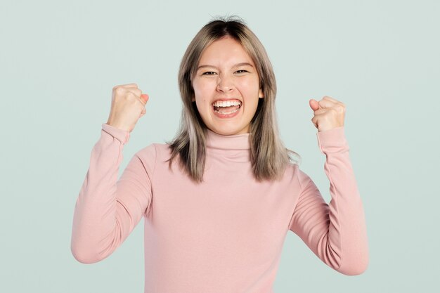 Mujer feliz en un jersey de cuello alto rosa