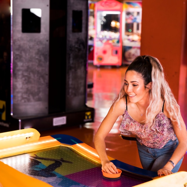 Mujer feliz jugando air hockey