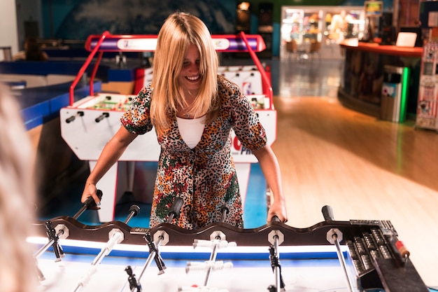 Mujer feliz jugando al futbolín