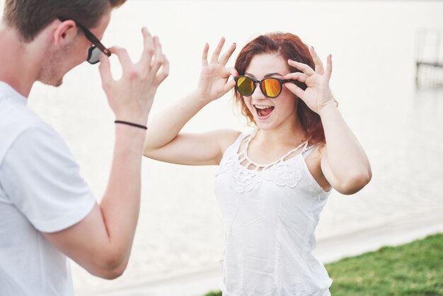 Mujer feliz y juguetona con su esposo en gafas de sol