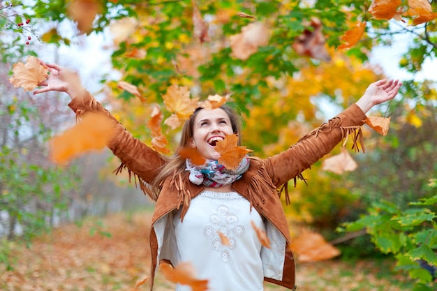 Foto gratuita mujer feliz lanza las hojas