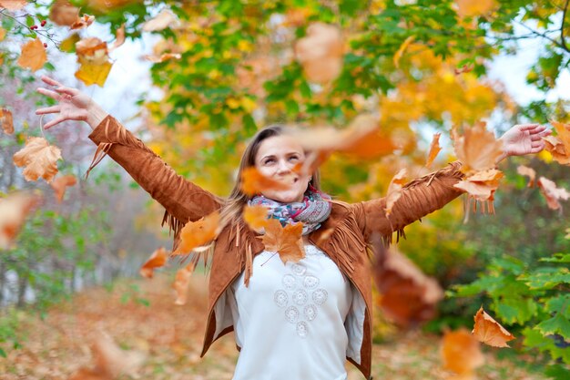 Mujer feliz lanza las hojas