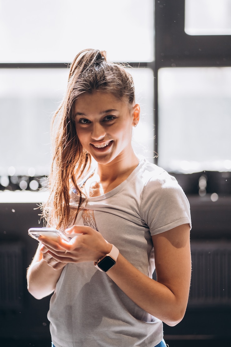 Foto gratuito mujer feliz leyendo un mensaje en un teléfono inteligente en casa