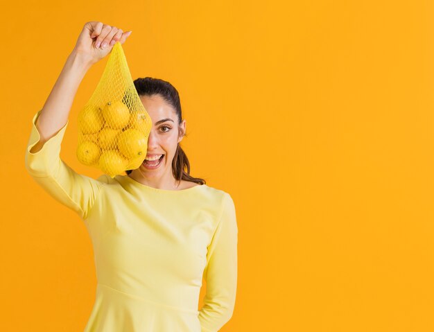 Mujer feliz con limones