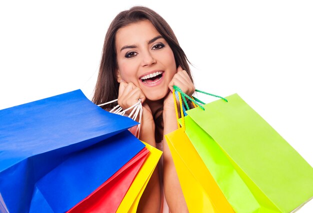 Mujer feliz con llena de bolsas de la compra.