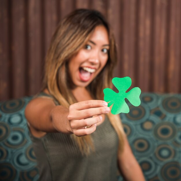 Mujer feliz llorando con trébol de papel verde