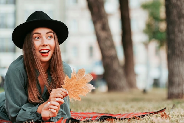 Mujer feliz en una manta en la naturaleza