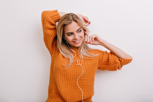 Mujer feliz con maquillaje elegante relajante con música favorita y pensando en algo agradable