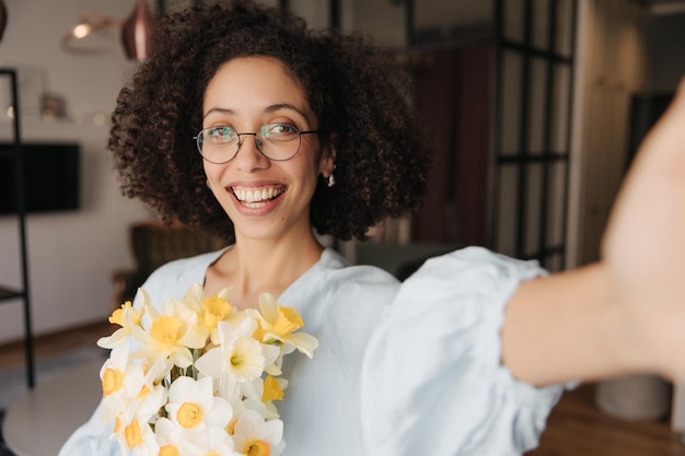 Foto gratuita mujer feliz mirando a la cámara con flores