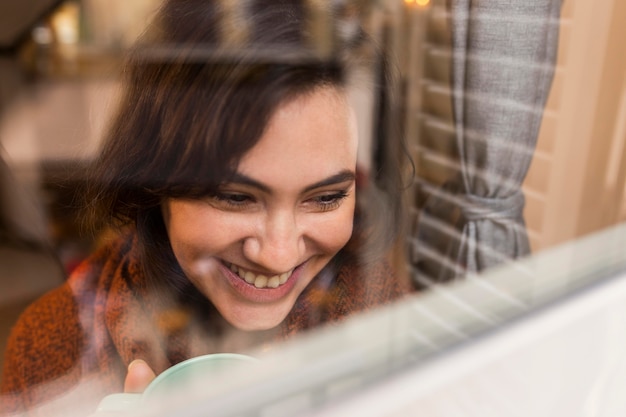 Mujer feliz mirando por la ventana