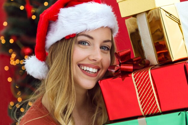 Mujer feliz con una montaña de regalos de colores en sus manos