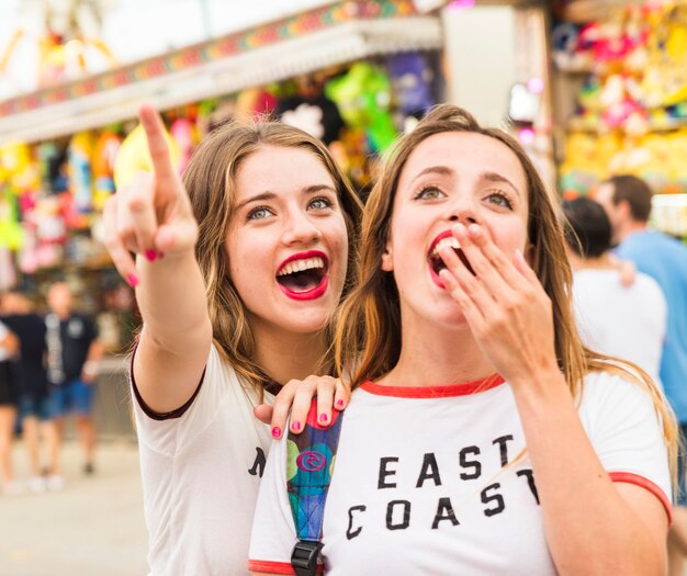 Mujer feliz mostrando algo a su amiga