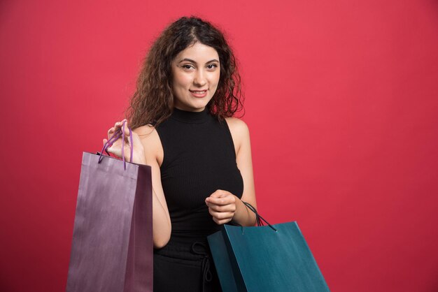 Mujer feliz con muchas bolsas en rojo