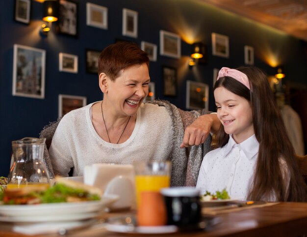 Mujer feliz y niña en la mesa